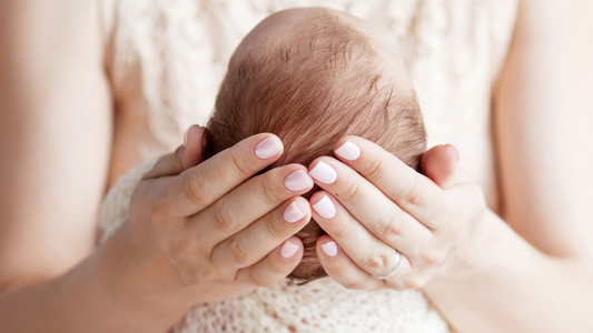 baby's head in mom's hands