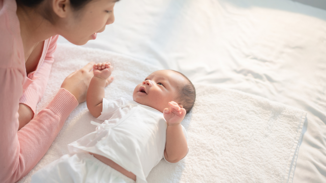 mom playing with newborn