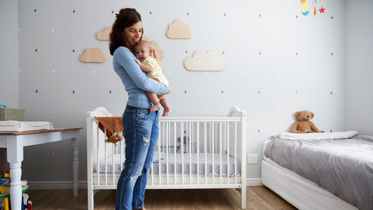 mom holding baby in nursery