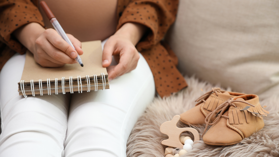 pregnant mom writing baby registry checklist
