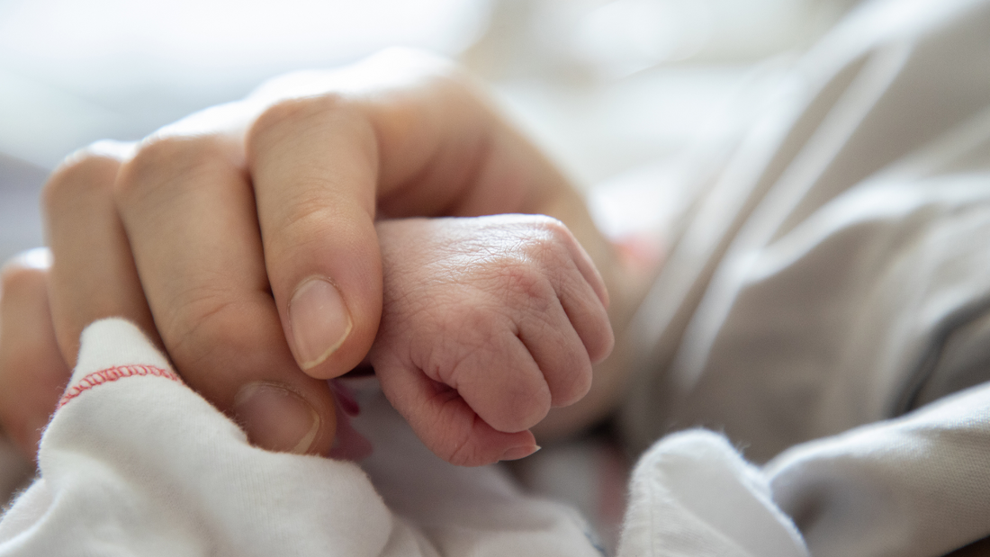 mom holding baby's hand