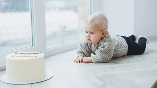 baby looking at half birthday cake